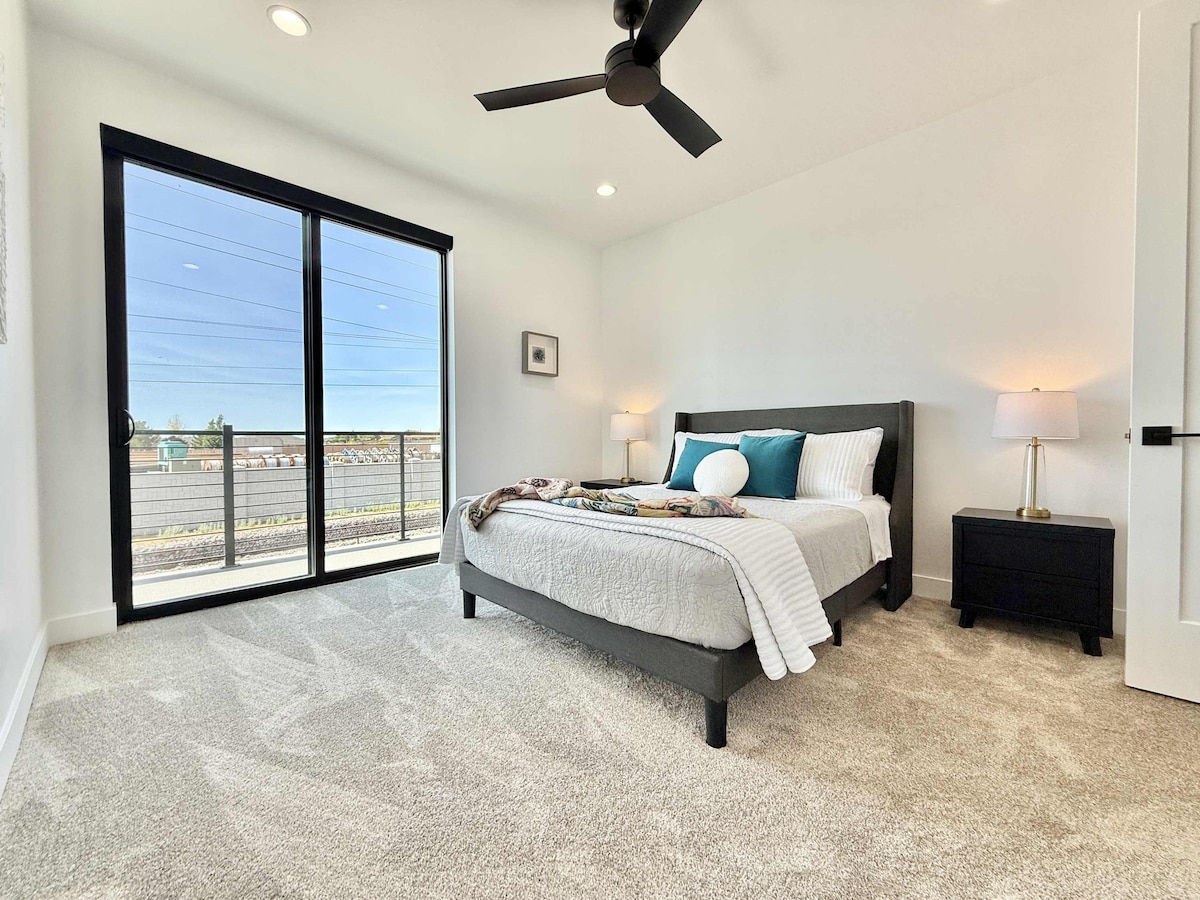 La suite principal en el piso de arriba ofrece una cama tamaño queen, baño privado y acceso al balcón.