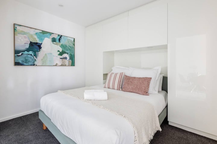 Uživajte u drugoj spavaćoj sobi s bračnim krevetom koja je uređena s mekim osvjetljenjem, gornjim policama i umirujućom paletom boja za miran san.