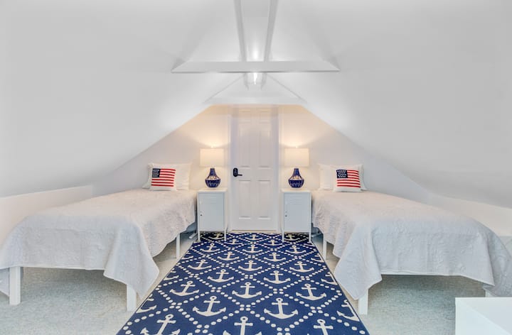 Chumba cha roshani kilicho na vitanda viwili pacha vya mtu mmoja na televisheni.