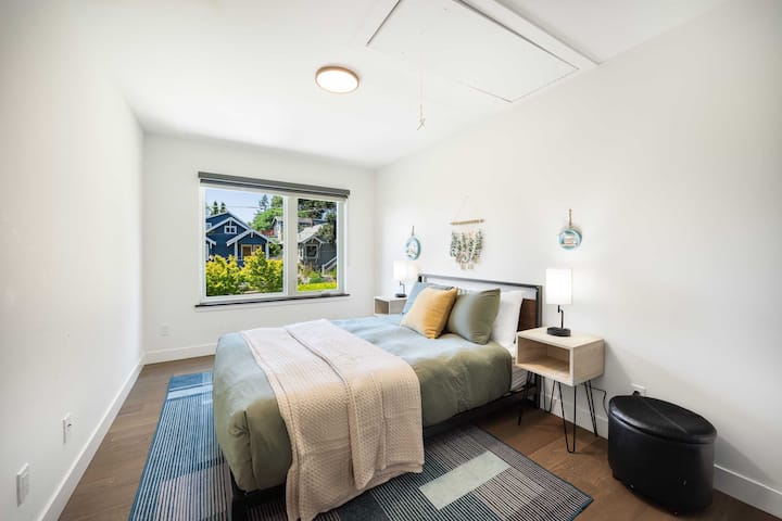 Prozračna bijela spavaća soba sa svjetlozelenom posteljinom, savršena za lijenčarenje nedjeljom ujutro.