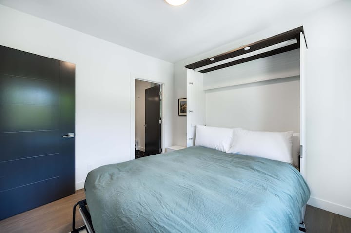 Svijetloplavi krevet na zidu oslobađa prostor na podu, a klizna vrata skrivaju domišljato rješenje za pohranu.