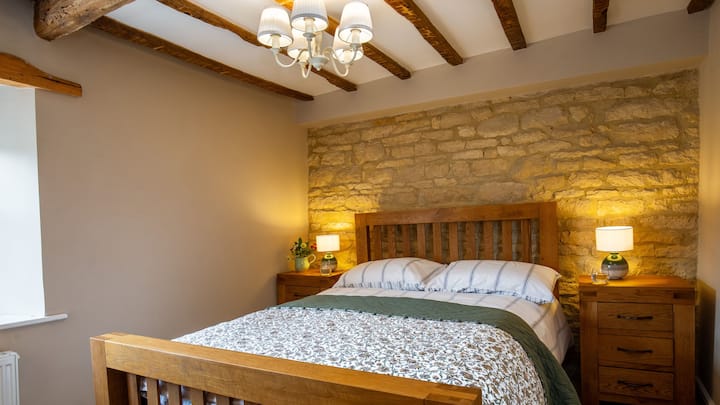 V druhej spálni s manželskou posteľou vás upúta odkrytá kamenná stena a trámový strop.