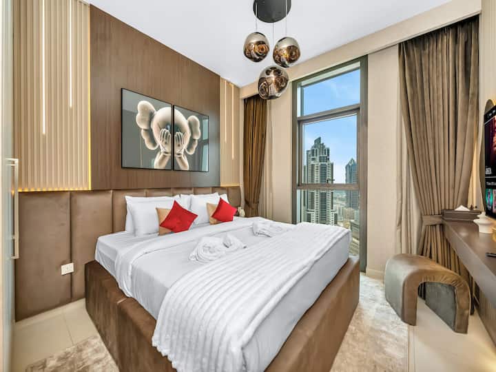 Elegante letto dal design moderno, illuminazione a LED, opere d'arte uniche di Bearbricks e viste mozzafiato sul centro di Dubai. Questa lussuosa camera da letto crea una miscela perfetta di comfort e stile artistico per un soggiorno indimenticabile.