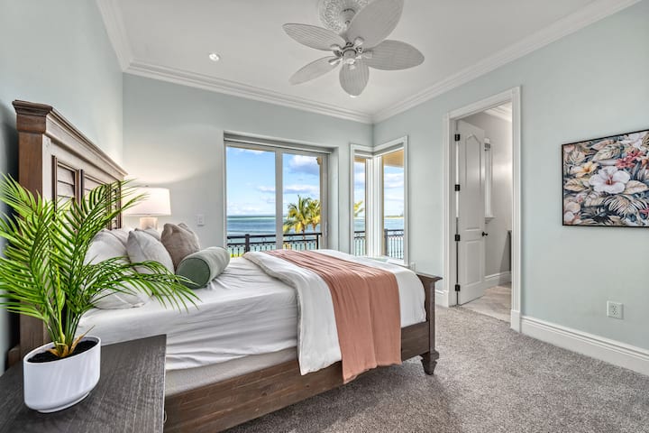 Dormitorio 4 con cama tamaño queen y acceso al balcón donde las texturas suaves y los tonos costeros establecen un tono sereno.