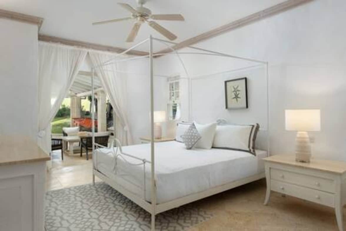 Tranquilo dormitorio principal con una cama tamaño king de EE. UU., baño con ducha, puertas francesas que conducen al jardín y aire acondicionado.