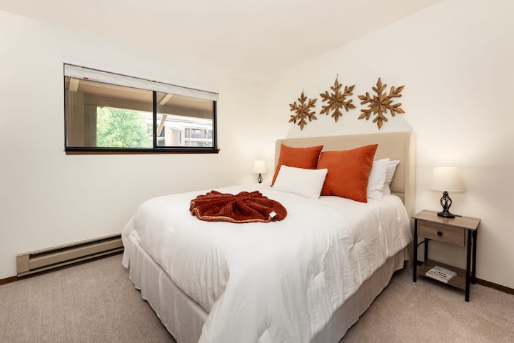 在您宁静的卧室里漂浮，配有毛绒床上用品、温暖的秋季装饰，窗外可欣赏宁静的街区景观。