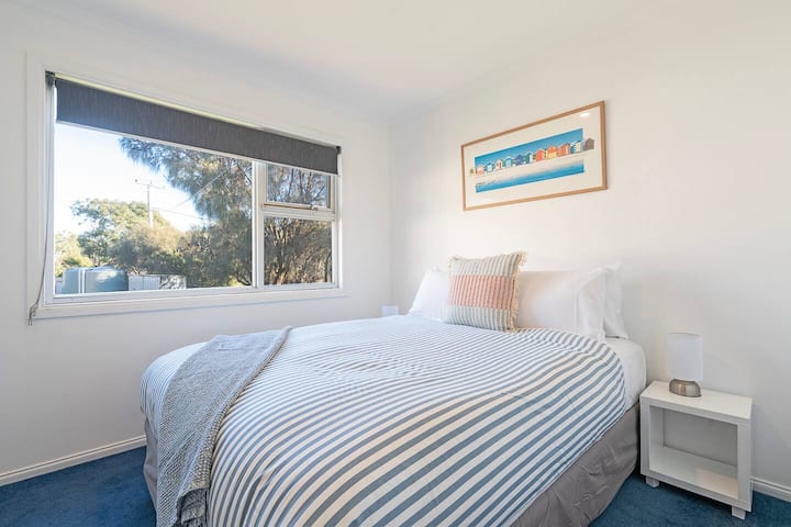 Tucked away for peace and privacy, the third bedroom offers a queen bed and a leafy outlook, perfect for quiet evenings.