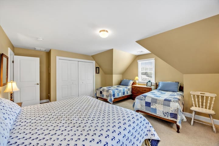 image 63 of 77, This sunlit room features a queen-size bed, a writing desk, and lovely backyard views.
