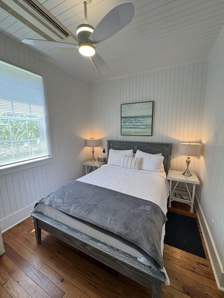 Queen bed with all white linens.