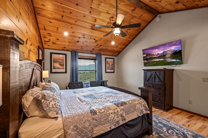 Apartmán s manželskou posteľou King | Relax a odpočinok – vychutnajte si pokojnú noc v tejto klenutej spálni s mäkkou manželskou posteľou King, televízorom s plochou obrazovkou a útulným sedadlom. Teplé drevené tóny a moderné vybavenie vytvárajú dokonalý horský únik.