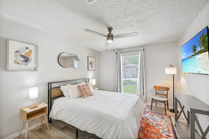 חדר שינה מואר ונעים עם עיצוב מודרני, אור טבעי ונוף שקט לגינה.