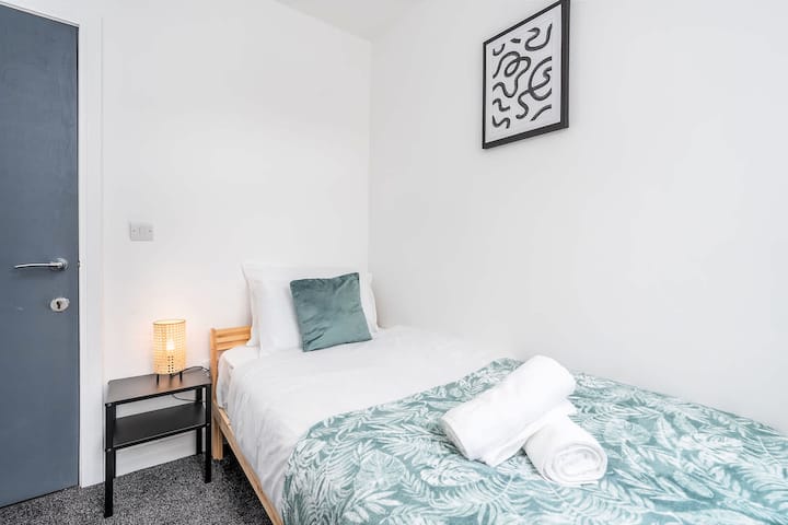 Svetlá jednolôžková spálňa s čerstvými uterákmi