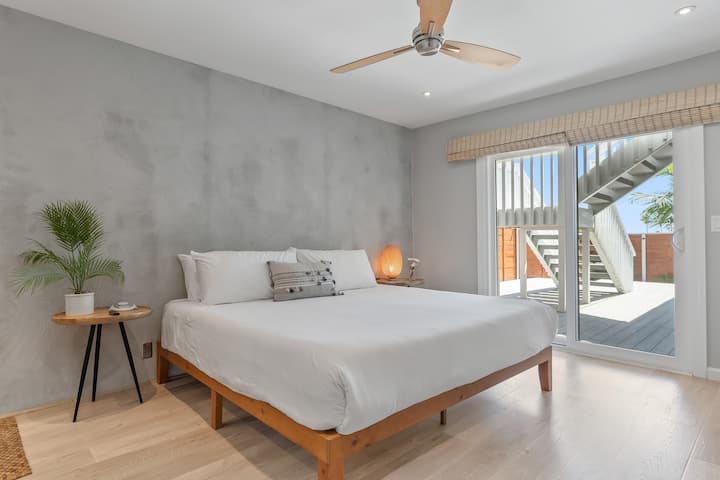 Chumba cha kulala cha 1 kina kitanda cha kifalme, ufikiaji wa baraza na bafu la chumba cha kulala.