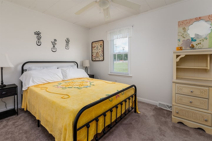 Slaapkamer 2: queensize bed, gezellige verlichting en veel opbergruimte met kasten en boekenkasten om je thuis te voelen.