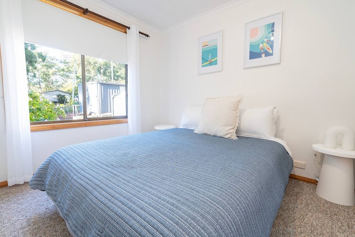 Втората брачна спална соба нуди мирно прибежиште, со мека природна светлина и крајбрежни уметнички дела кои носат весел шмек во просторот.