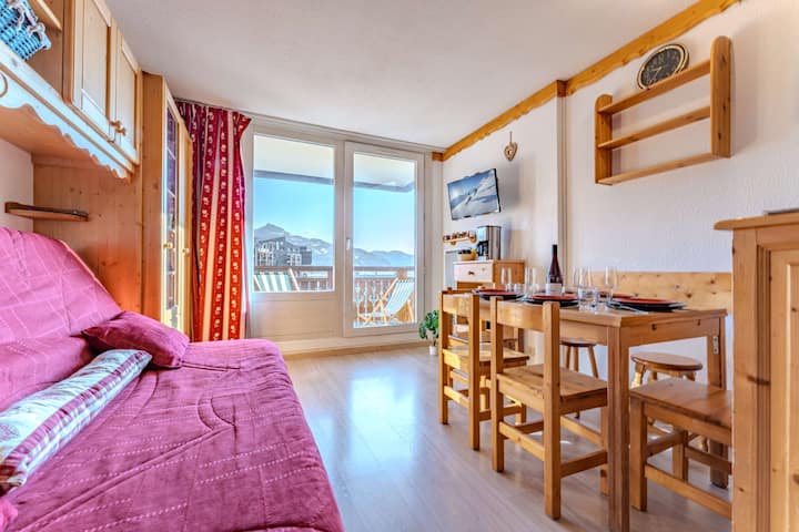 Всекидневна с балкон и гледка към планината в сърцето на Вал Торенс. Насладете се на естествена светлина, уютно пространство и директен достъп до балкон с спираща дъха гледка към Трите долини.