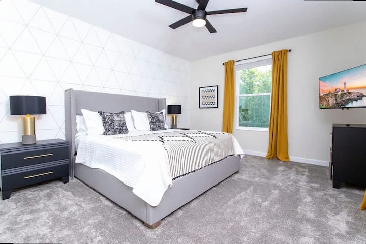 Oddýchnite si v tejto sofistikovanej hlavnej spálni s luxusnou manželskou posteľou, štýlovou stenou s geometrickými akcentmi a televízorom pre maximálnu relaxáciu.