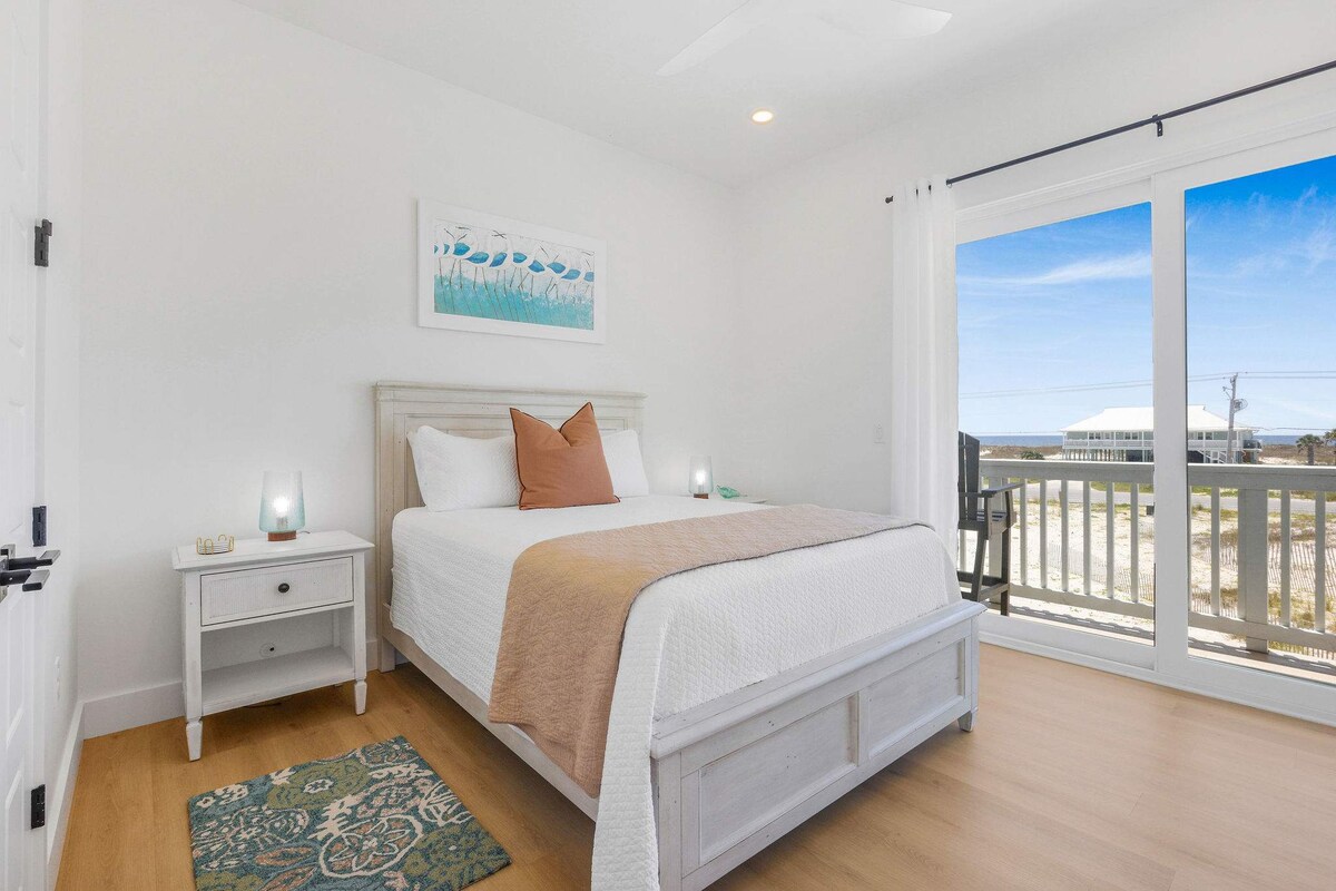 חדר שינה 2 בקומה הראשית עם נוף לחוף, מיטת קווין סייז, חדר אמבטיה פרטי ומרפסת פרטית. 