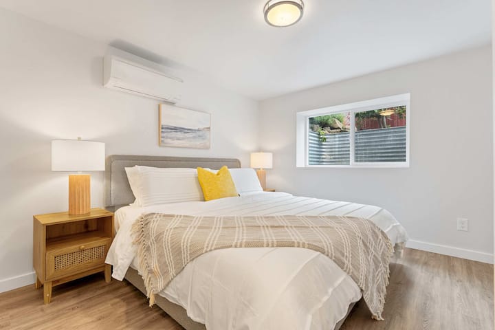 Pokojné útočisko s čistou bielou bielizňou a teplými odtieňmi dreva.