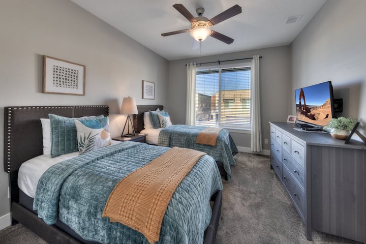 A bright and comfortable twin bedroom designed as a flexible sleeping space for kids, teens, or additional adult guests.
