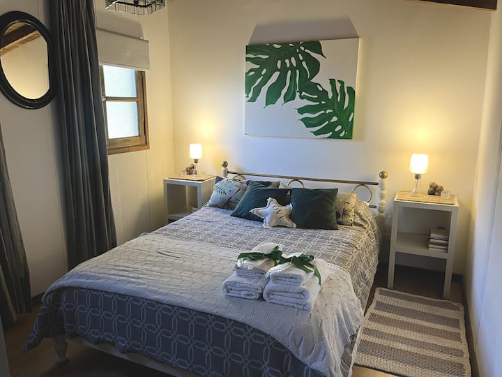 Главна спална соба на најгорниот кат, со двоен кревет, паметен телевизор, заштитен простор и топла и спокојна атмосфера за одмор помеѓу шумата и тишината.