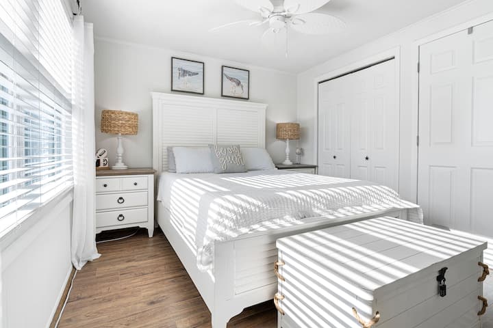 מיטת קווין סייז נוחה עם מצעים מפנקים — מושלמת לחופשה רגועה על שפת הים.