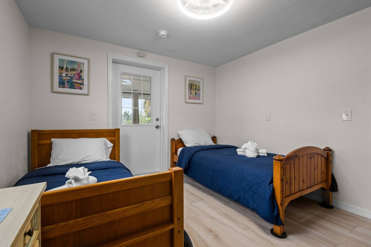 سريران مفردان في غرفة ضيوف مليئة بالضوء يوفران مساحة ترحيبية للأطفال أو الأصدقاء للاستقرار والشعور وكأنهم في بيوتهم.