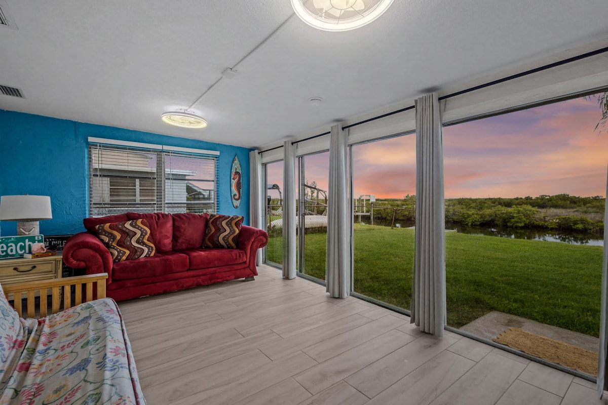 تجلب النوافذ الممتدة من الأرض إلى السقف الهواء الطلق إلى الداخل، مما يخلق بقعة مشرقة للاسترخاء مع إطلالات هادئة على المياه.