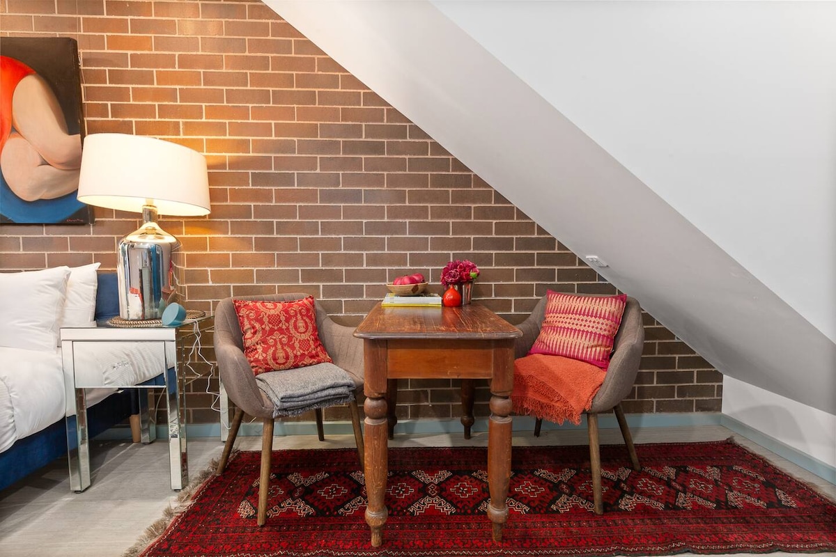 Intimni stol za dvoje u ovom studio apartmanu nalazi se na tepihu s istaknutim uzorkom i pruža ugodno mjesto za uživanje u zalogaju ili brzom doručku.
