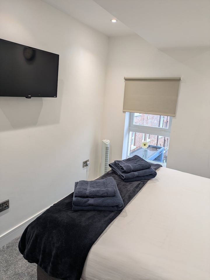 Apartamento 24 – Dormitorio 1 con vista a la calle tranquila - Amplio dormitorio principal con cama zip-link (configurada como king o doble), TV inteligente y persianas opacas.