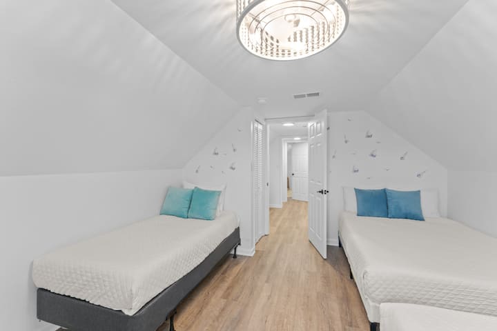 Rummeligt gæsteværelse med to queensize-dobbeltsenge og en enkeltseng – ideel til grupper eller større familier