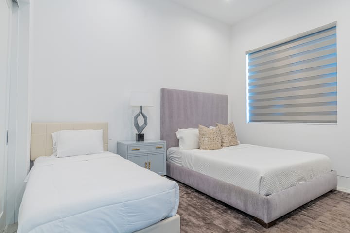 La chambre 5 dispose d'un très grand lit, d'un lit simple et d'une salle de bain attenante.