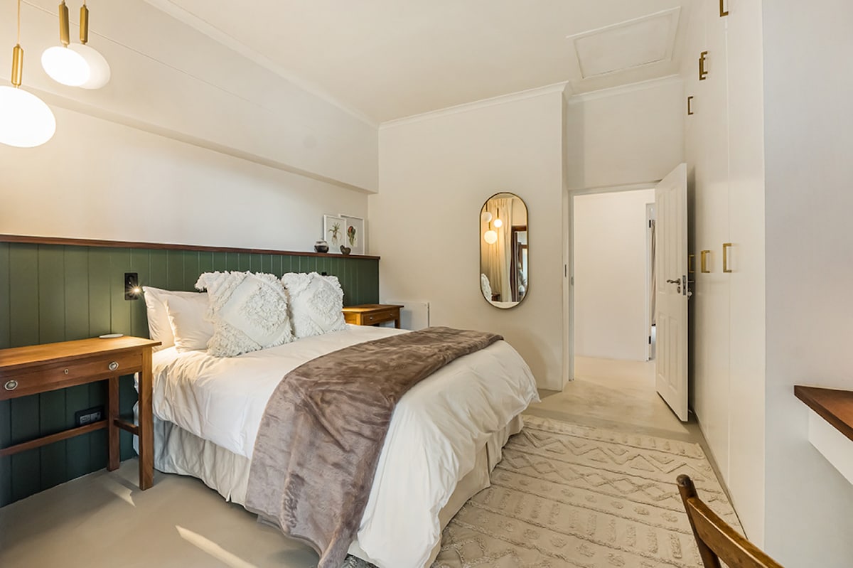 Een gezellige maar elegante slaapkamer met rijke, rustgevende tinten en moderne accenten - perfect om te ontspannen na een dag vol avontuur.