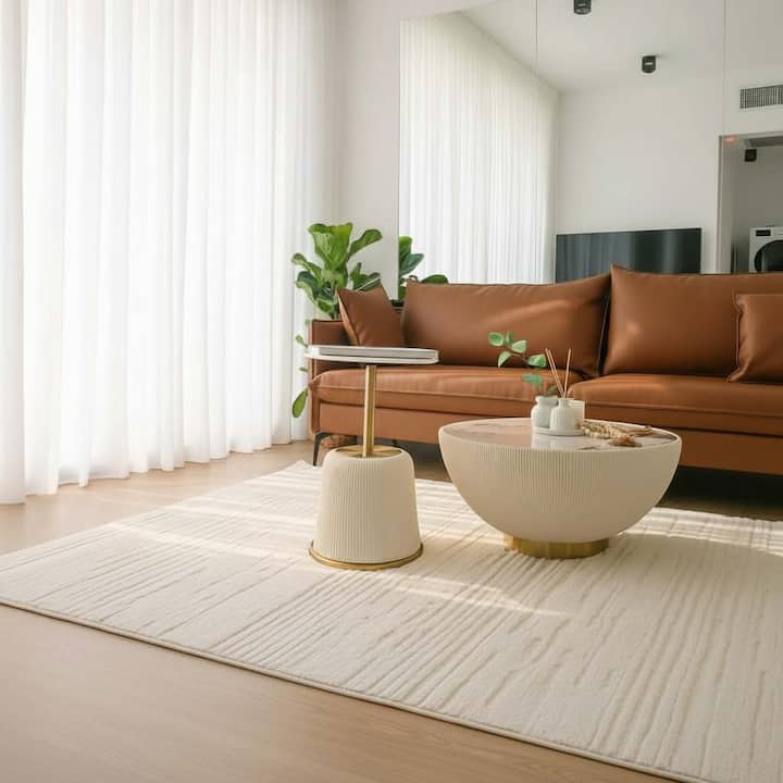 Una elegante mesa de centro y una alfombra suave completan la acogedora sala de estar, perfecta para disfrutar de tardes de descanso en interiores.