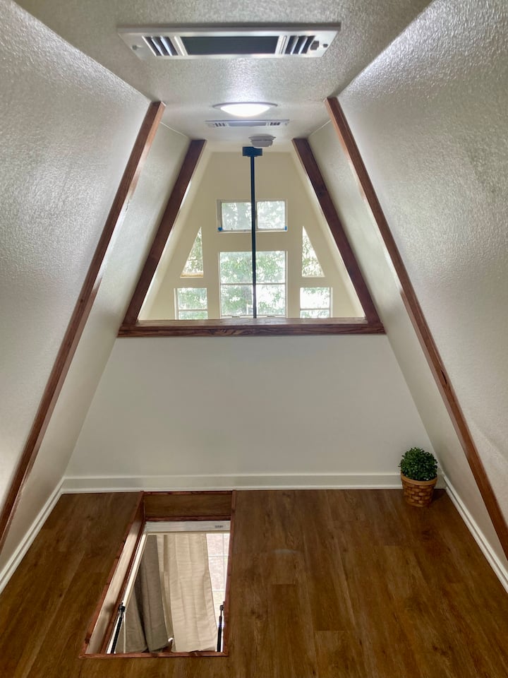 Врв на поткровје во форма на буквата А со прозорец: шармантен А-рамка врв во поткровјето со природна светлина и удобно катче за читање