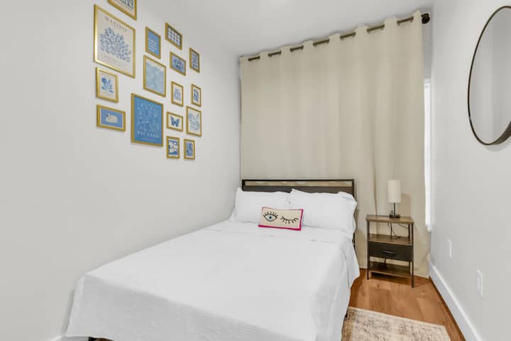 Spavaća soba s bračnim krevetom i šarenim umjetničkim detaljima.