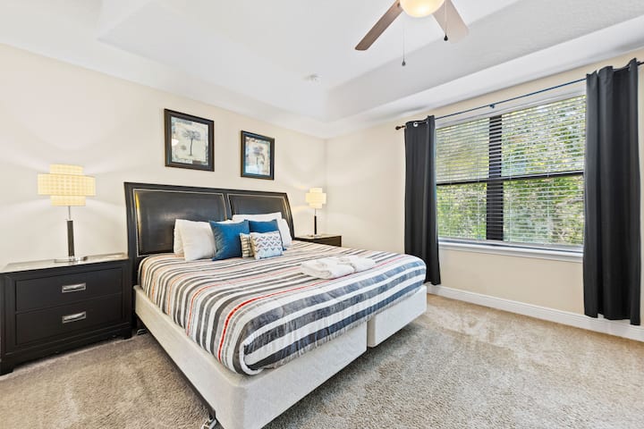 Amplia suite principal con cama tamaño king, ventilador de techo, televisor inteligente y baño privado para un retiro tranquilo.