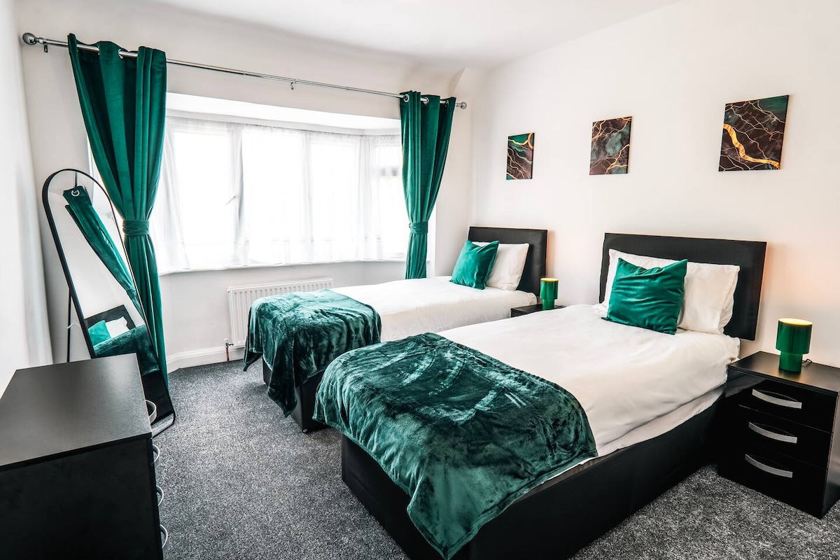 Chumba cha kulala chenye mandhari ya kijani kibichi chenye matandiko laini, dirisha kubwa na mapazia ya kuzima – bora kwa ajili ya kulala kwa utulivu baada ya siku moja huko Wembley au kuchunguza London.