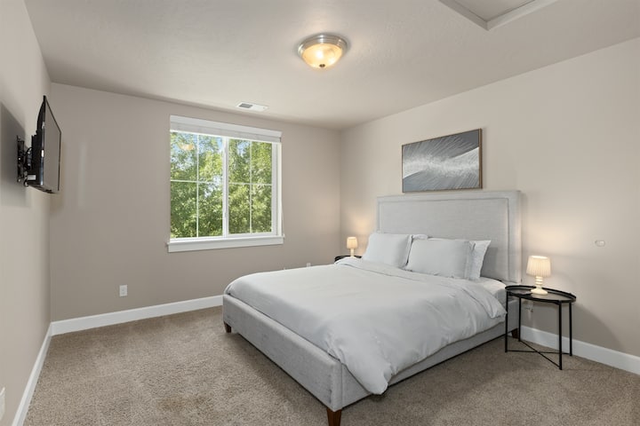 غرفة نوم مريحة للضيوف مع تلفزيون.