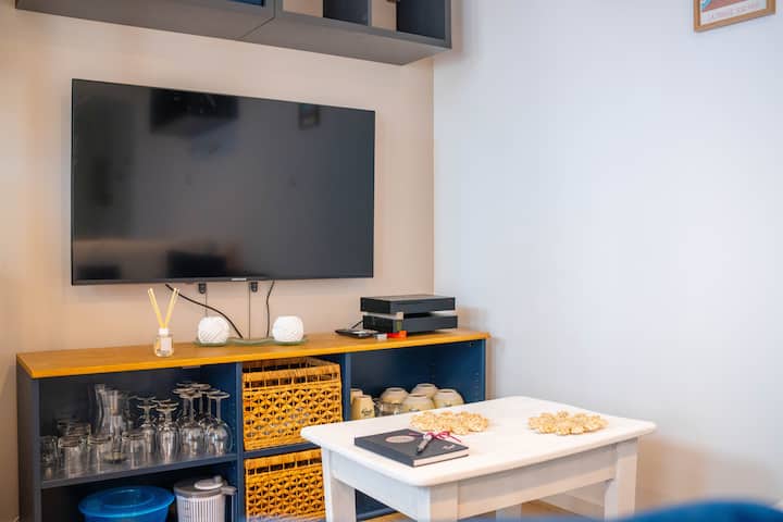 غرفة معيشة عصرية مزودة بتلفزيون، رائعة للاستمتاع ببرامجك المفضلة.