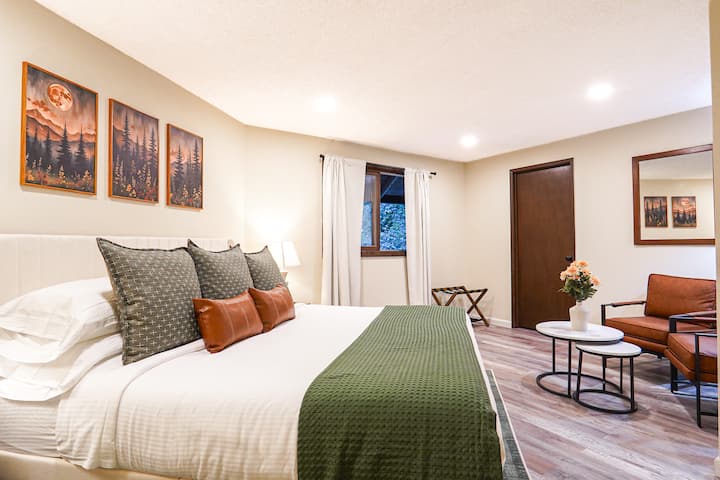 Spálňa na poschodí s posteľou Helix veľkosti King a útulným priestorom na posedenie. 