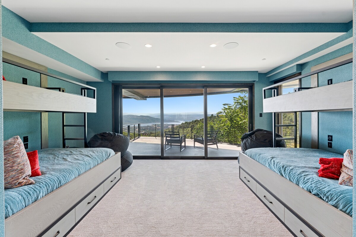 ლუქს‑კლასის ნომერი ორარუსიანი საწოლებითა და ფანჯრებით, რომლებიც იატაკიდან ჭერამდეა