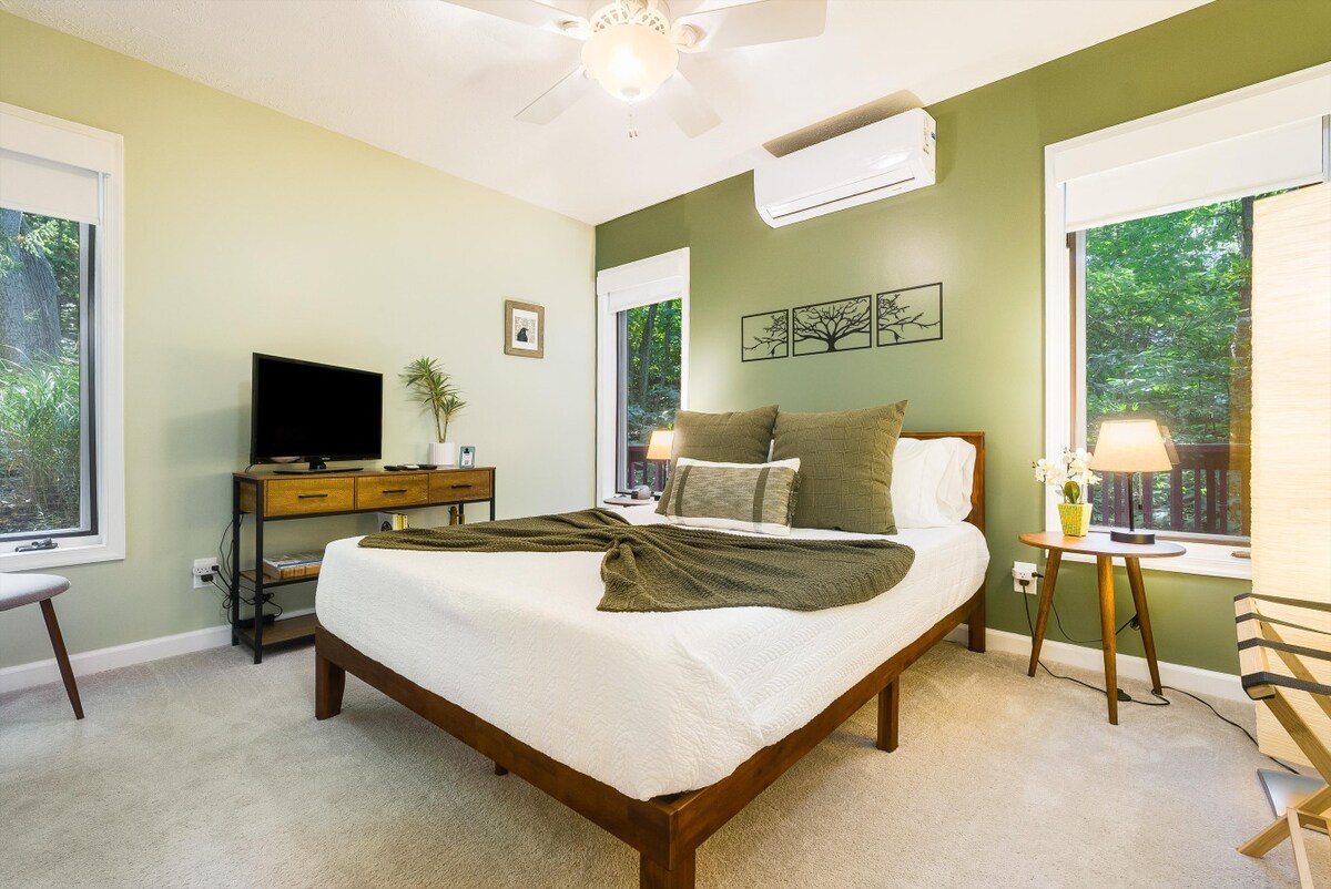 غرفة خضراء، مع خزانة ملابس كاملة وتلفزيون مزود بخدمة Roku.