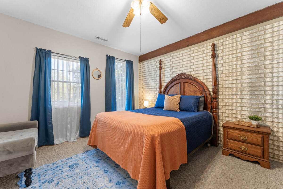 غرفة النوم رقم 2 | مساحة مريحة مع سرير بعمودين، جدار من الطوب المزخرف وإضاءة طبيعية دافئة