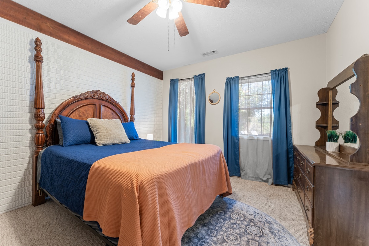 غرفة النوم الثالثة | مشرقة وجذابة مع سرير كلاسيكي بأربعة أعمدة، جدار من الطوب وأثاث خشبي غني