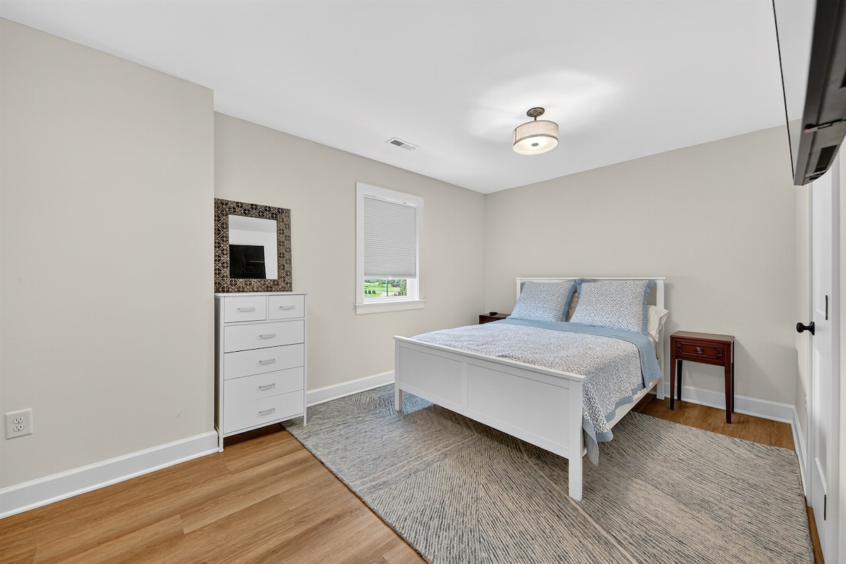 Acogedor y acogedor dormitorio de invitados con un marco de cama blanco fresco y tonos neutros relajantes.