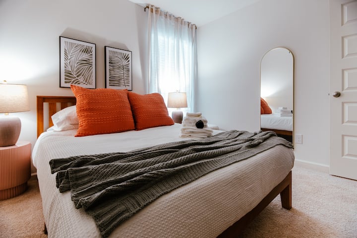 Queen bed with Purple Mattress, full-length mirror, and soft natural light.