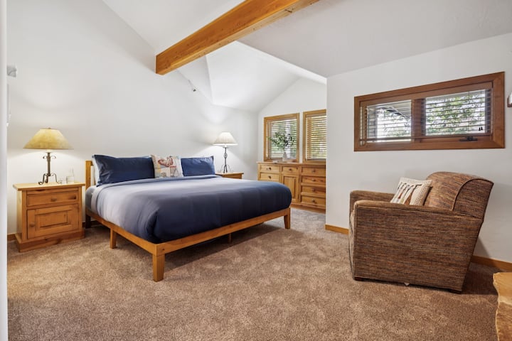 Hlavná spálňa má manželskú posteľ, gauč, televízor a krb.