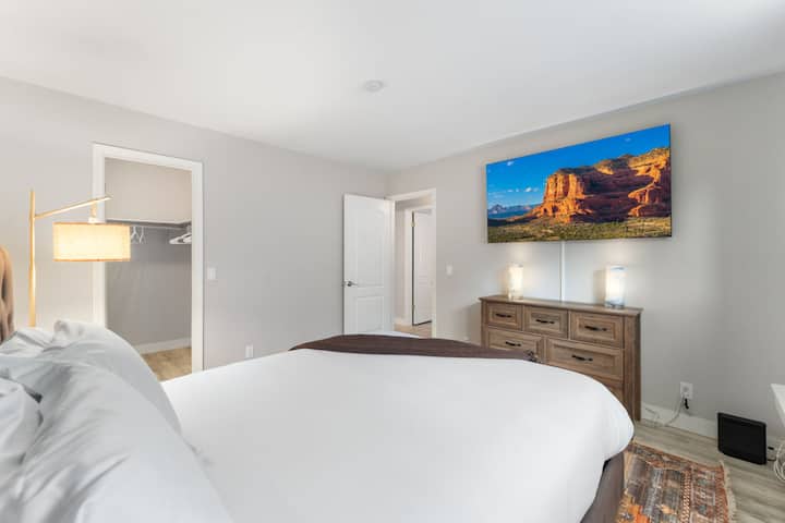 Chumba cha kulala chenye nafasi kubwa na runinga kwa ajili ya starehe na burudani.