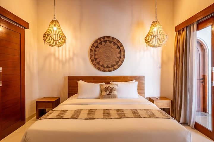 Елегантна главна спална соба со брачен кревет и минималистички стил.